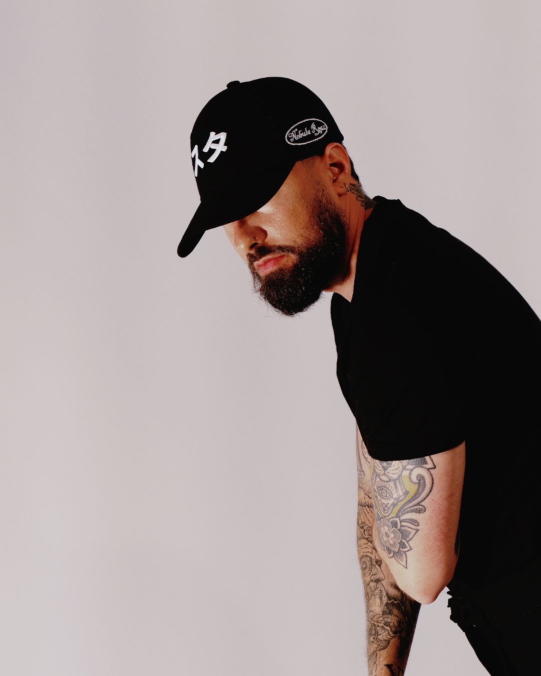 Hombre de perfil con gorra Sutā negra de Nebula Reaz