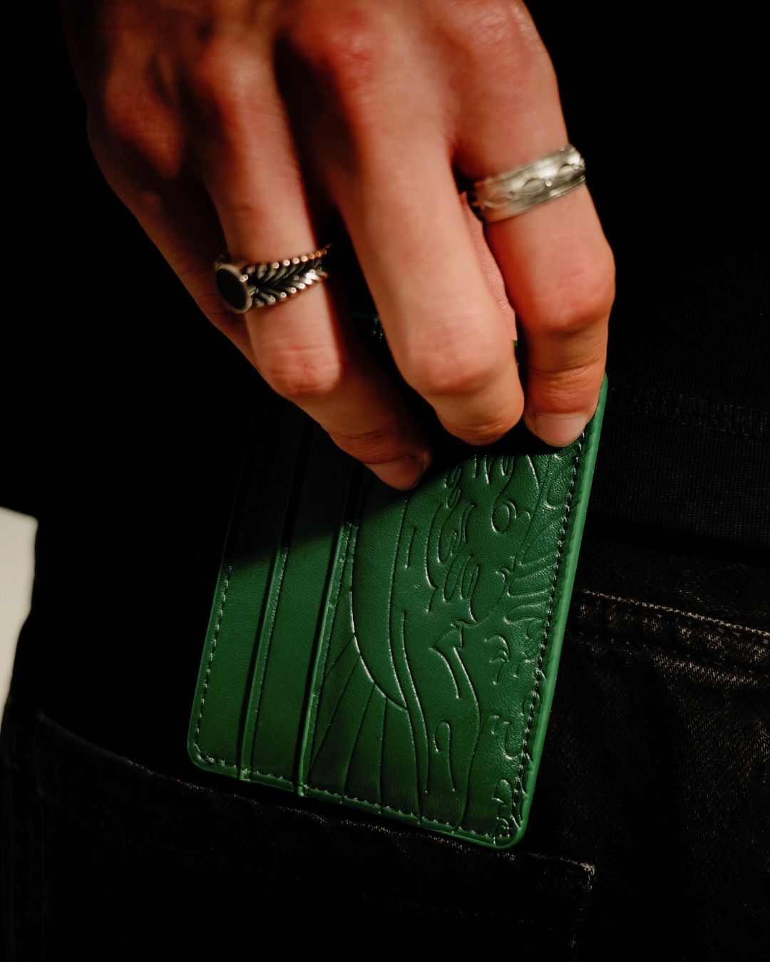 Mano sosteniendo la cartera Kanagawa verde de Nebula Reaz